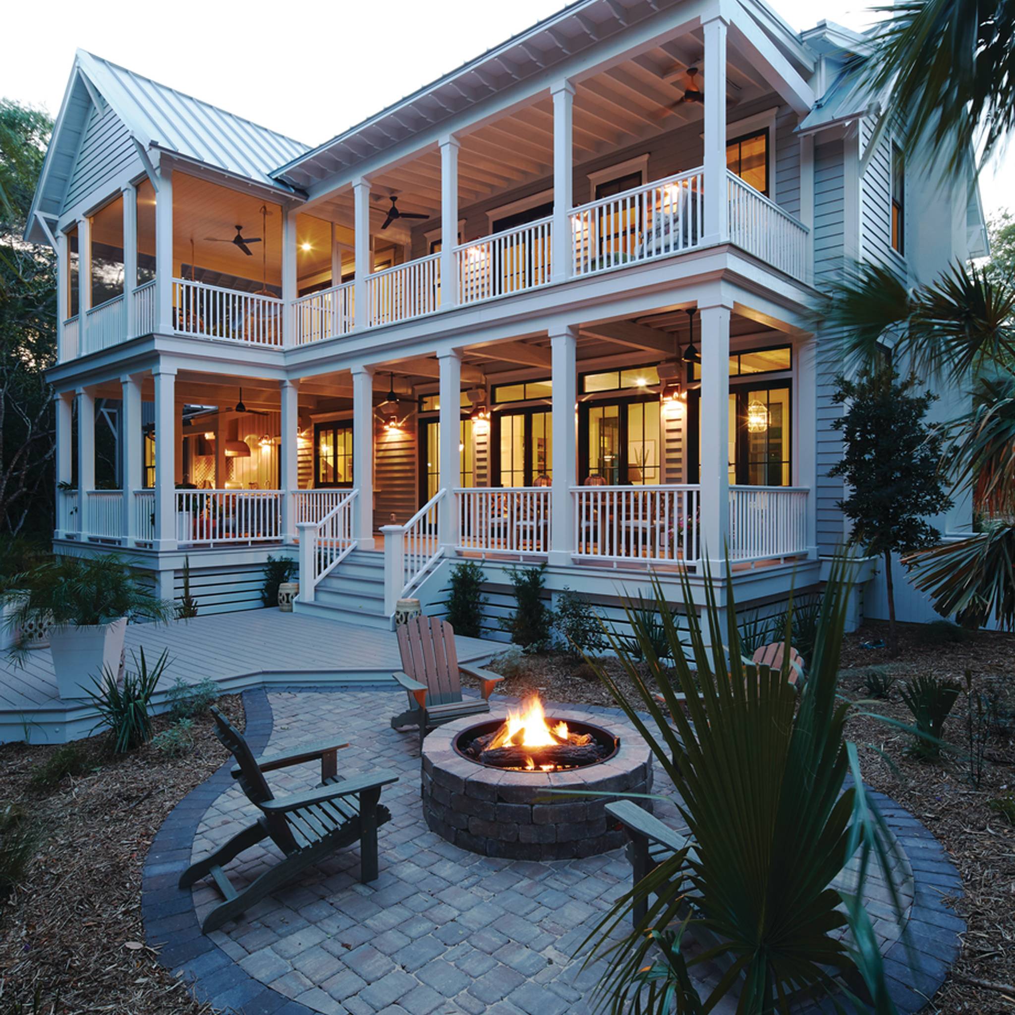 Modern home featuring AZEK Trim with elegant white PVC trim accents, spacious porch, and fire pit area, showcasing a stunning exterior design.