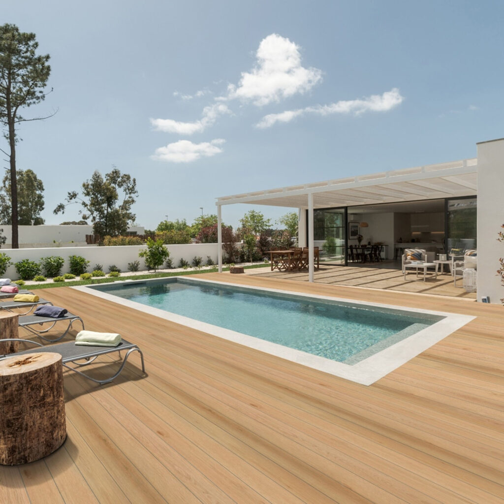 Eco-friendly bamboo composite decking in light wood tone by pool
