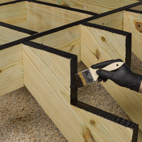 Applying FastenMaster Deck Frame Coating with brush on joist cuts