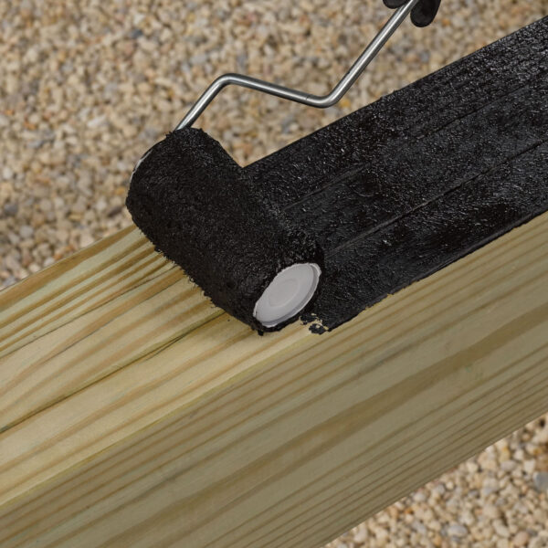 Rolling FastenMaster Deck Frame Coating onto deck frame lumber