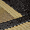 Close-up of water beading off coated deck joist